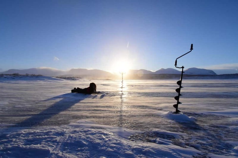 Abisko: Ice Fishing Experience - Drilling through the ice