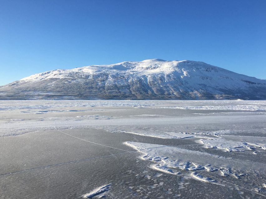 Abisko: Lake Torneträsk Arctic Ice Fishing Trip - Fishing through the ice near Abisko